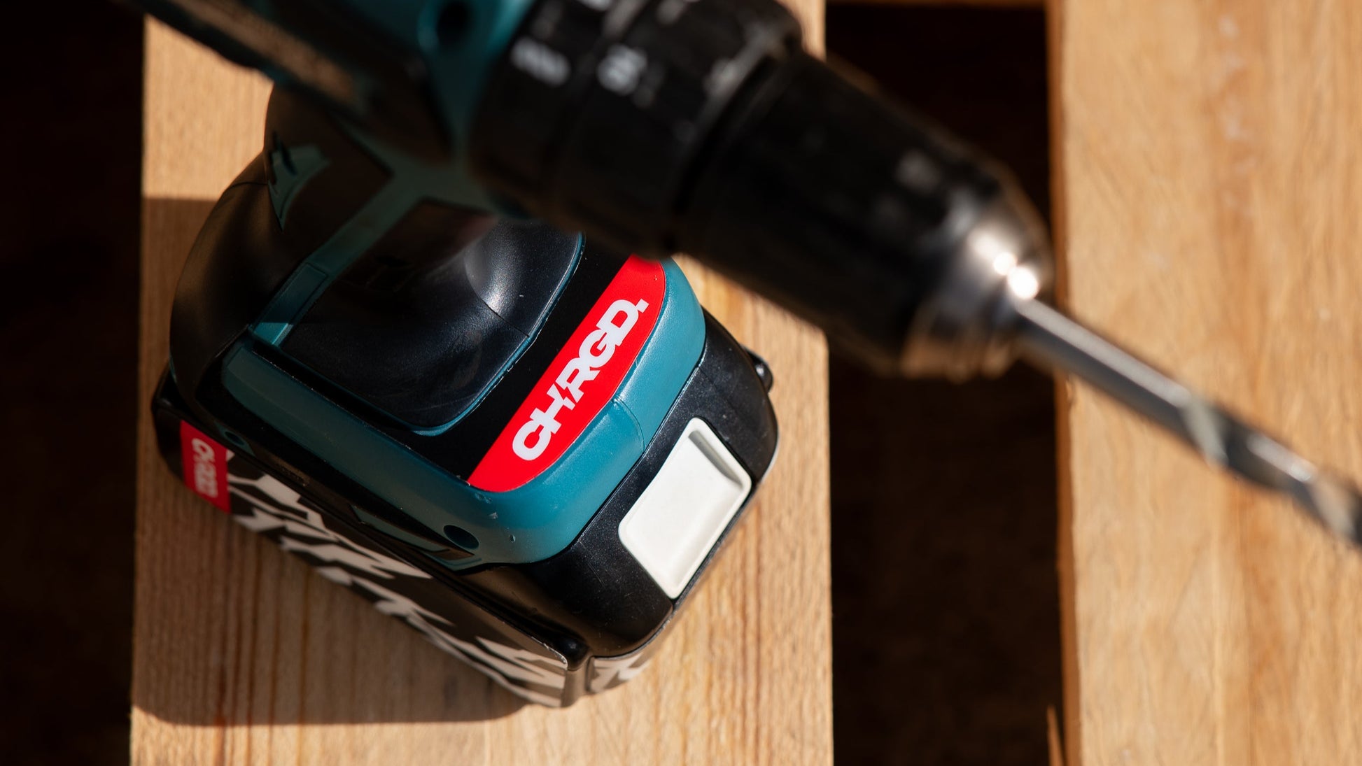 Cordless drill with a red and black design on a wooden surface